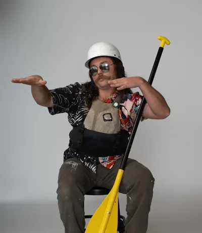 Donavon, in a hard hat and sunglasses, holding a paddle